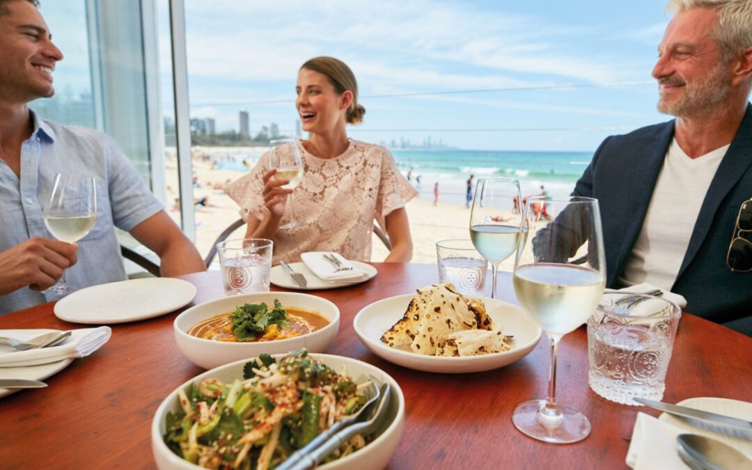 Couples dining at a beachfront Burleigh Heads restaurant with wine and share plates on a grown-ups weekend